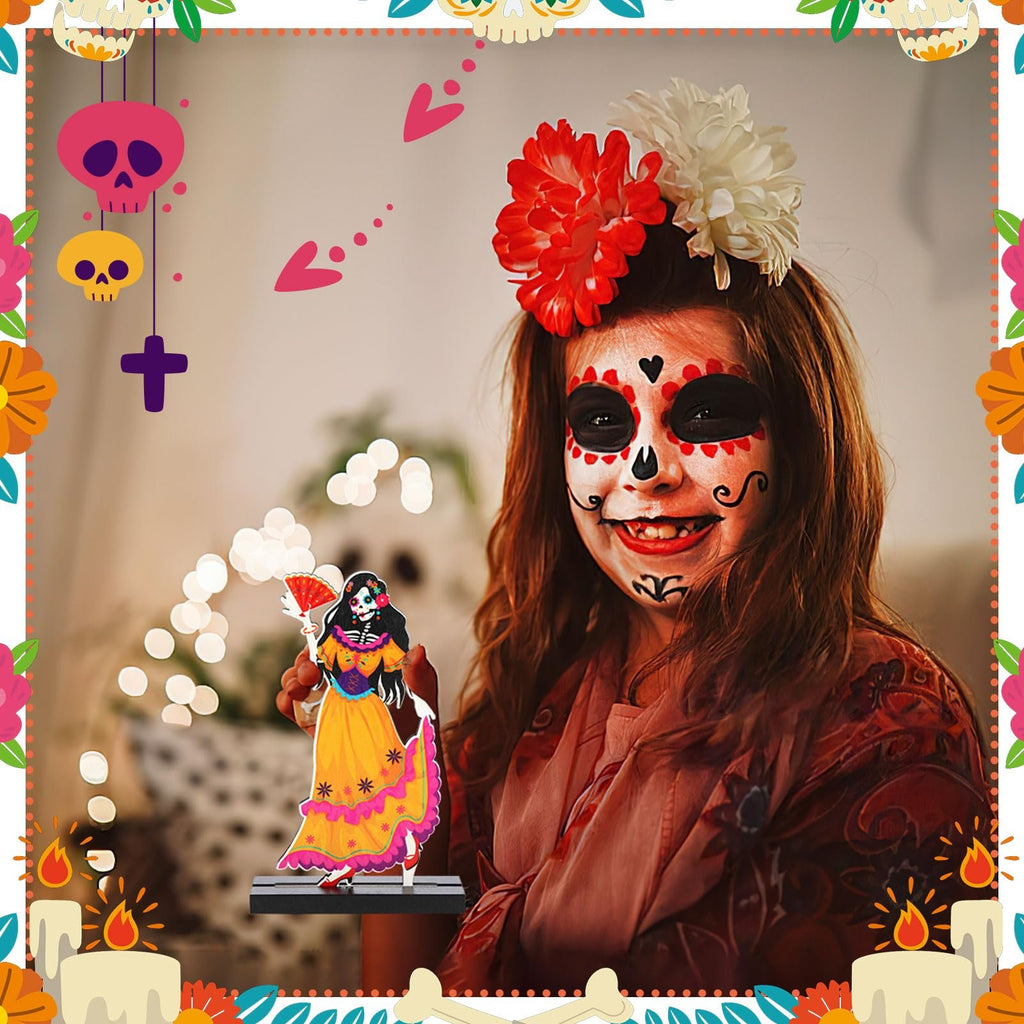 Girl with Day of the Dead face paint holding a sugar skull centerpiece figure, surrounded by festive decorations.