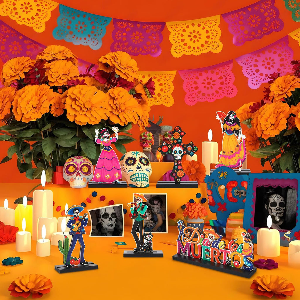 Day of the Dead centerpiece set with sugar skulls, figures, flowers, and papel picado banners.