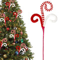Christmas tree decorated with red and white candy cane picks and ornaments. A close-up of two candy cane picks on a white background.