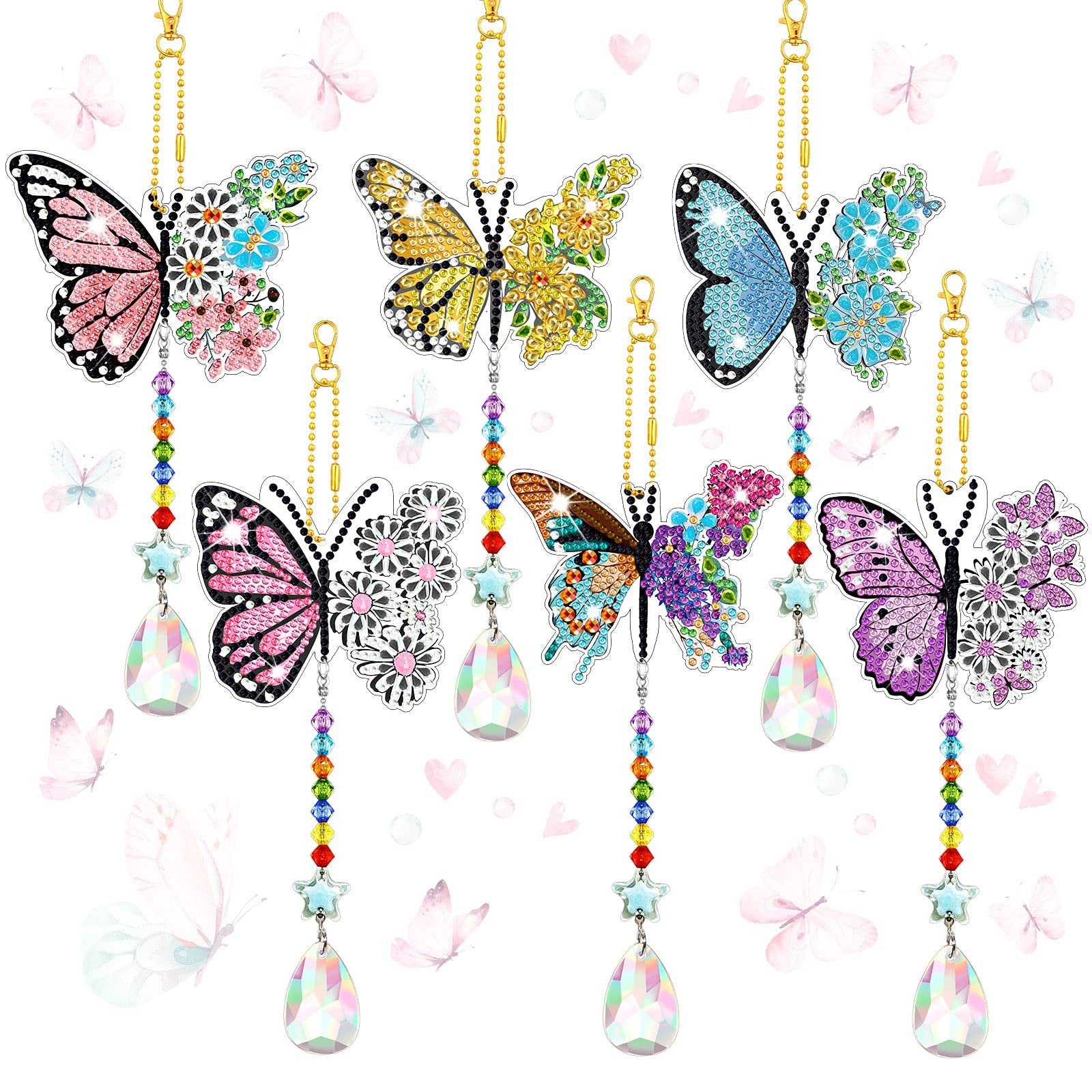 Six diamond painting butterfly suncatchers with crystal teardrop pendants and beaded chains hanging against a white background with faint butterfly and heart graphics.