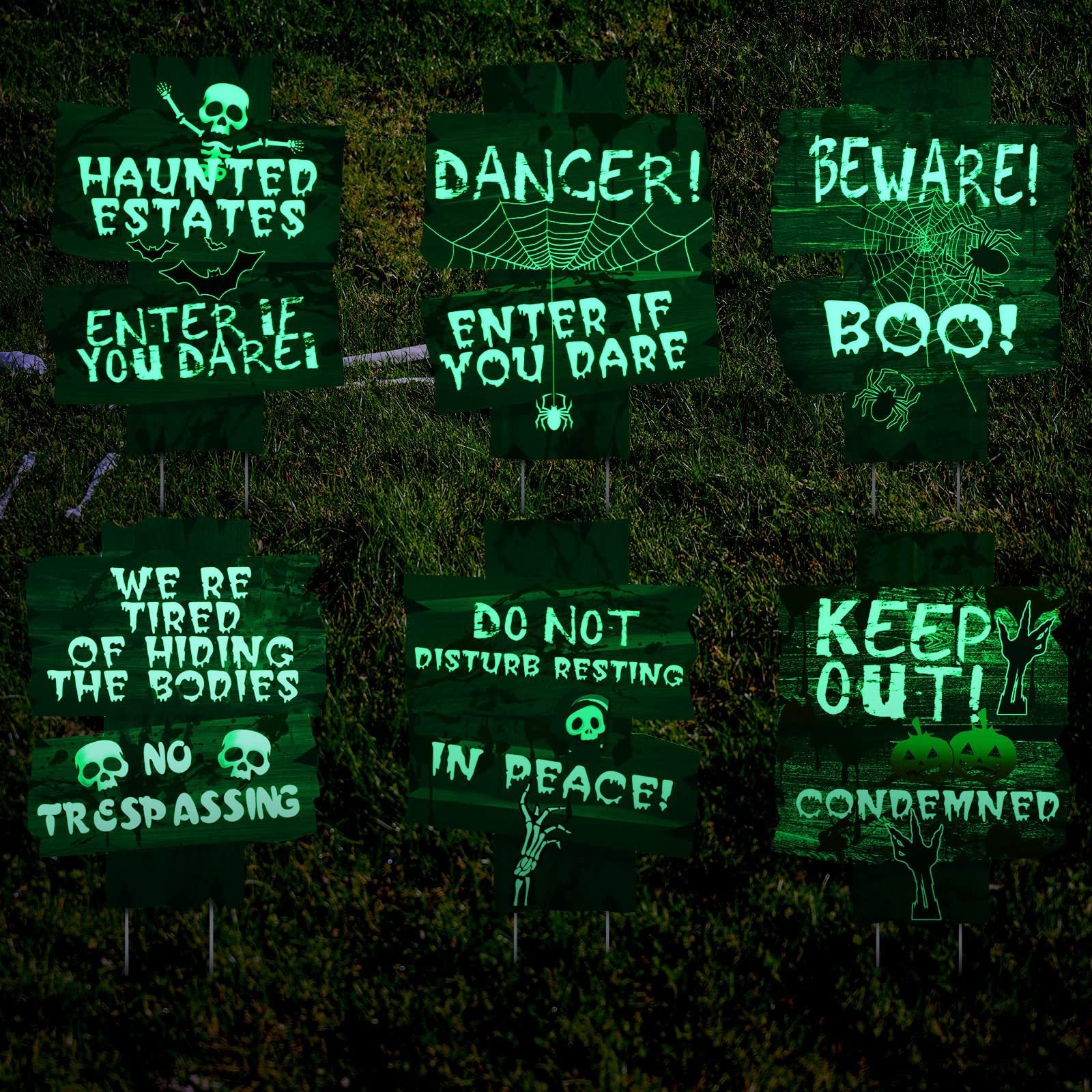 Six glow-in-the-dark Halloween yard signs with spooky messages and graphics, displayed on a grassy lawn.