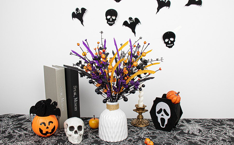 Halloween floral arrangement with black, purple, and orange berries and leaves in a white vase, surrounded by spooky decor.