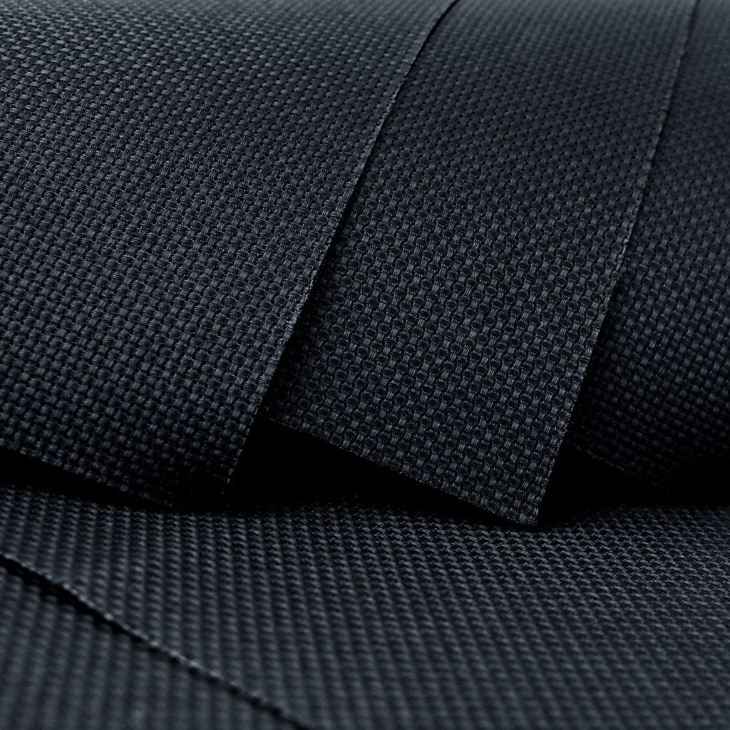 Close-up of black Aida cloth fabric showing its woven texture and count, with layers overlapping.