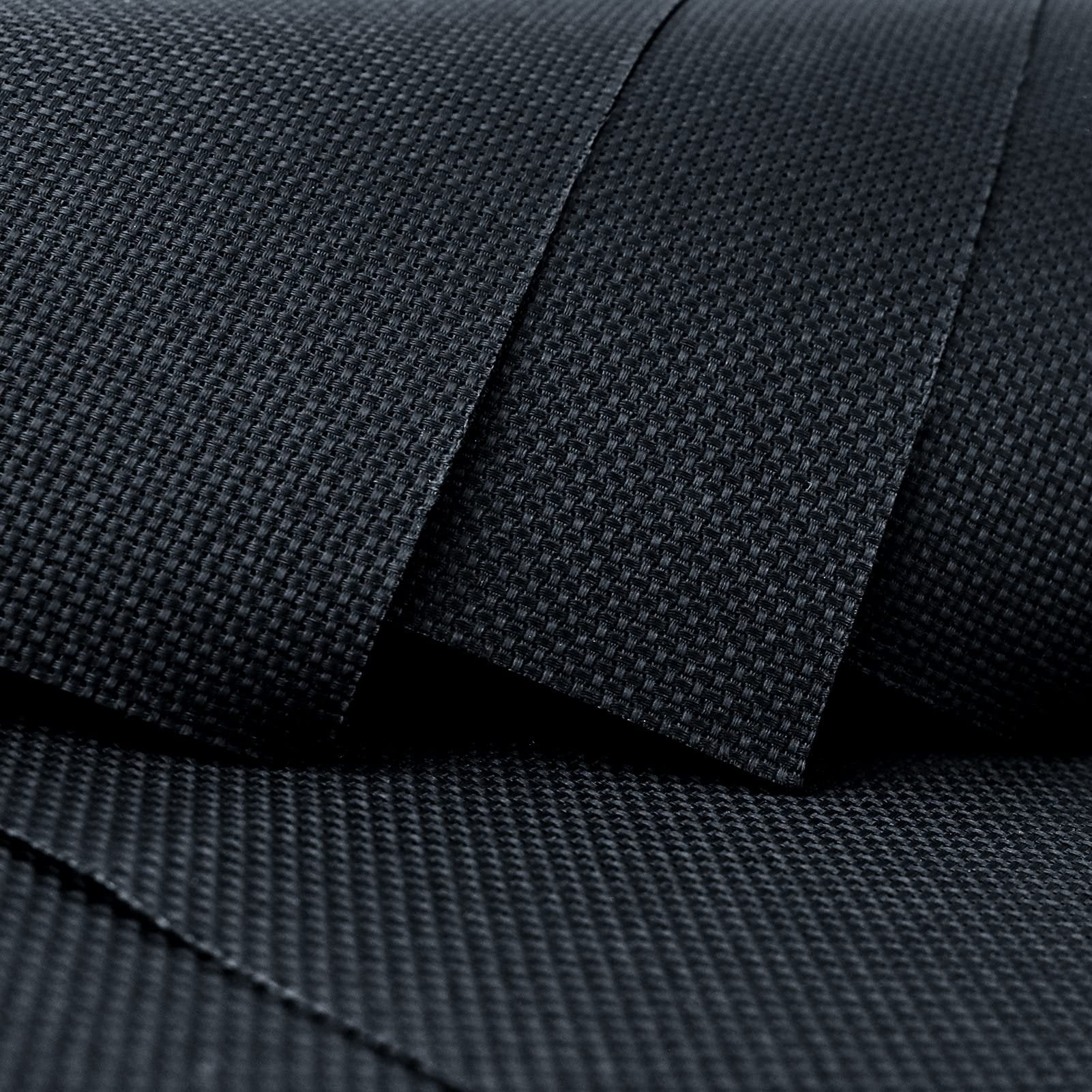 Close-up of black Aida cloth fabric showing its woven texture and count, with layers overlapping.