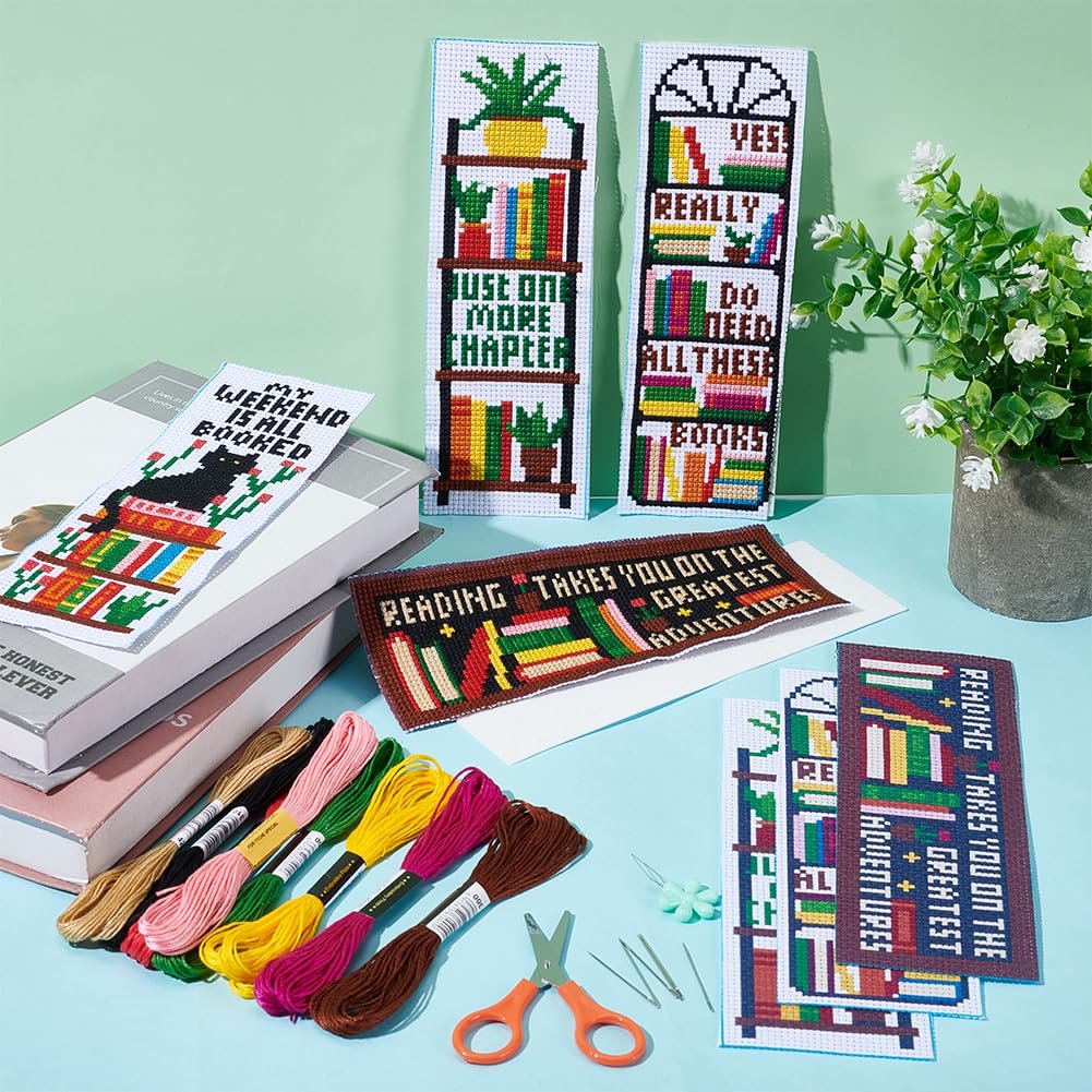 Cross stitch bookmark kit contents including finished bookmarks, embroidery floss, needles, and scissors.