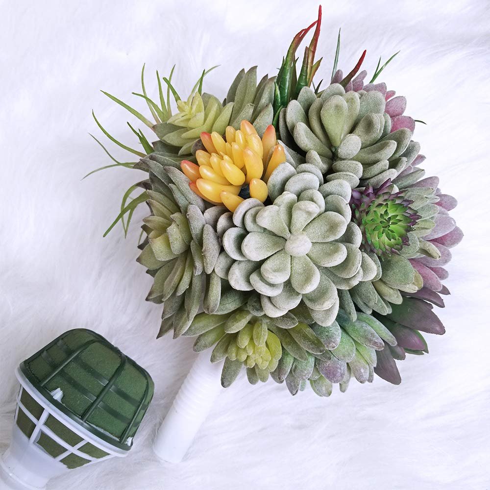 Artificial succulent bouquet with a floral foam holder on a white fluffy surface