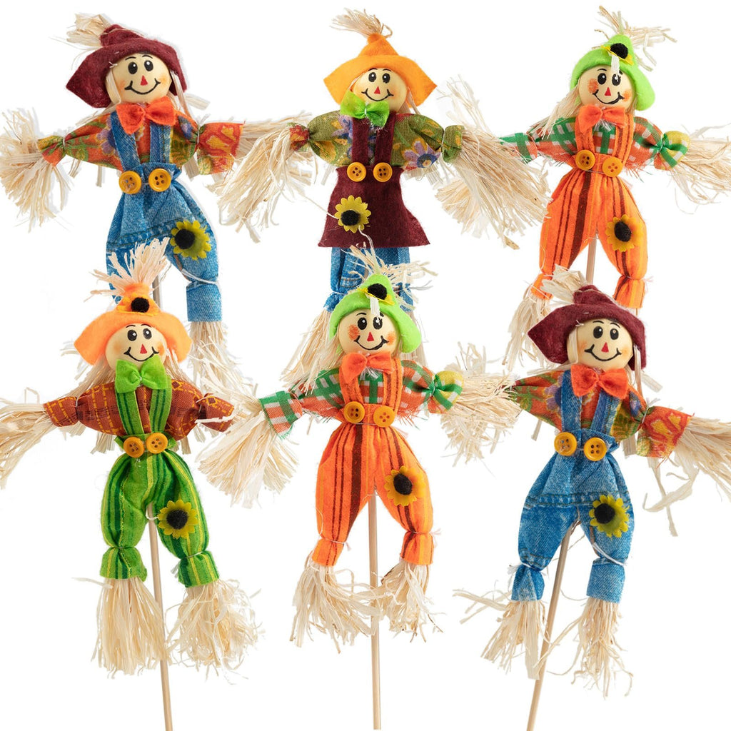 Six assorted fabric scarecrow decorations with straw accents and button details, displayed against a white background.