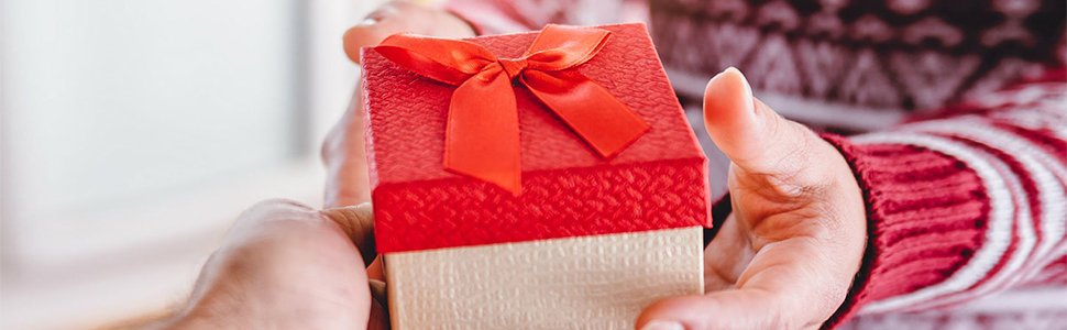 Hands exchanging a red and gold gift box tied with a red ribbon