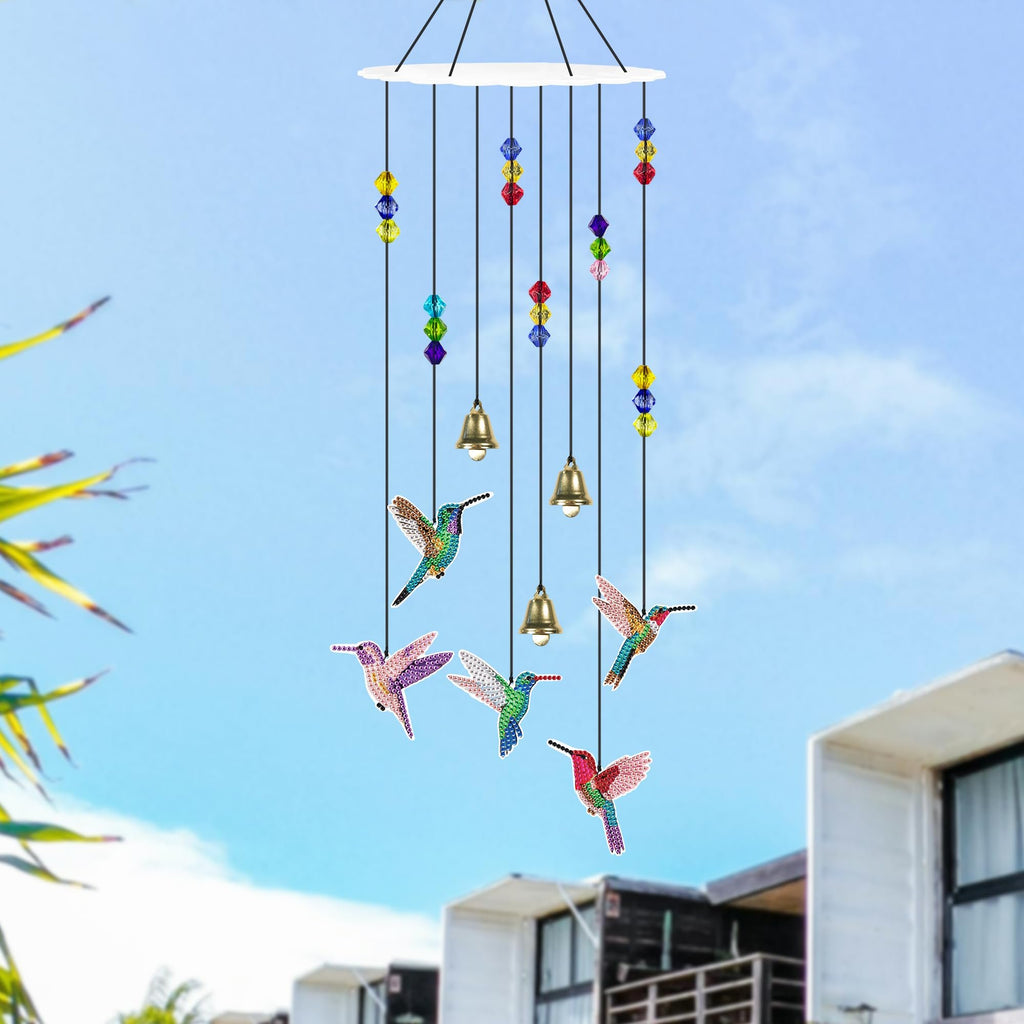 Hummingbird diamond painting wind chime with colorful beads and bells hanging against a blue sky.