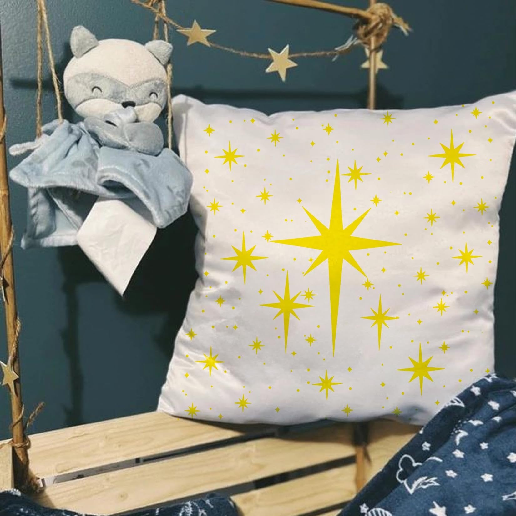 White pillow with yellow star pattern and a plush toy hanging nearby