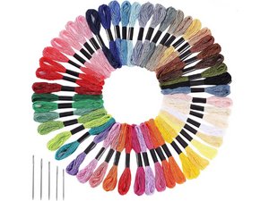 Assorted colors of embroidery floss arranged in a circle with needles on a white background