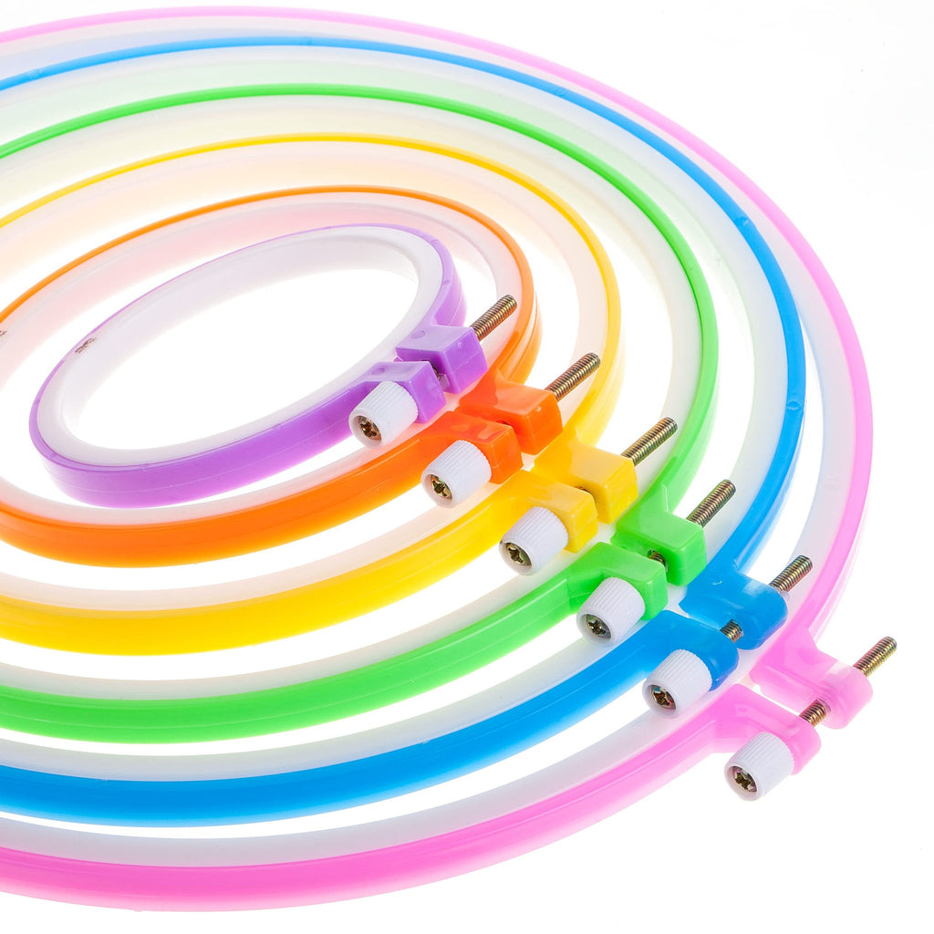 Assorted colored plastic embroidery hoops with adjustment screws, arranged in a curve against a white background.