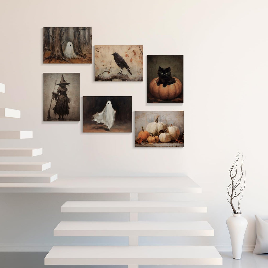 Six vintage Halloween canvas art prints depicting ghosts, a witch, a crow, a black cat in a pumpkin, and pumpkins, displayed on a white wall above white floating shelves.