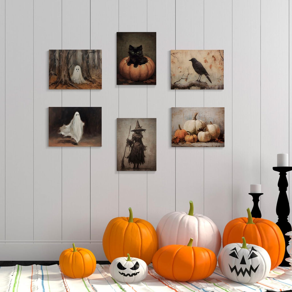 Six vintage Halloween canvas art prints displayed on a white paneled wall with pumpkins and candlesticks below.