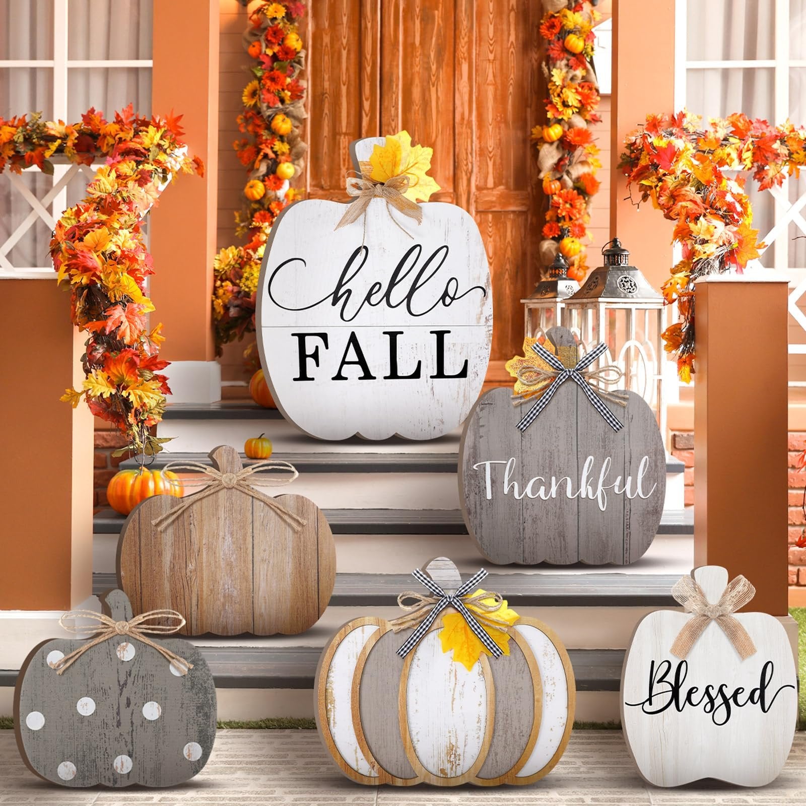 Set of six wooden pumpkins decorated for fall, arranged on porch steps with autumn garlands.