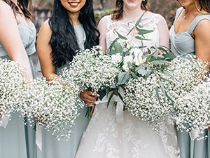 Bride and bridesmaids holding white artificial baby's breath bouquets at a wedding