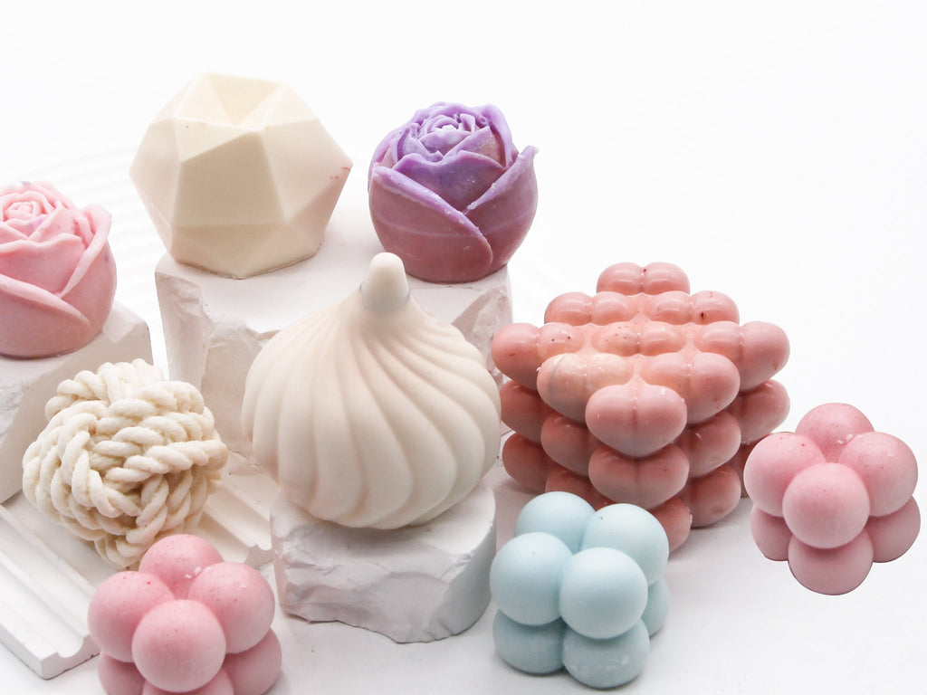 Assortment of decorative silicone molds in various shapes including roses, geometric, and bubble clusters, displayed on white blocks.
