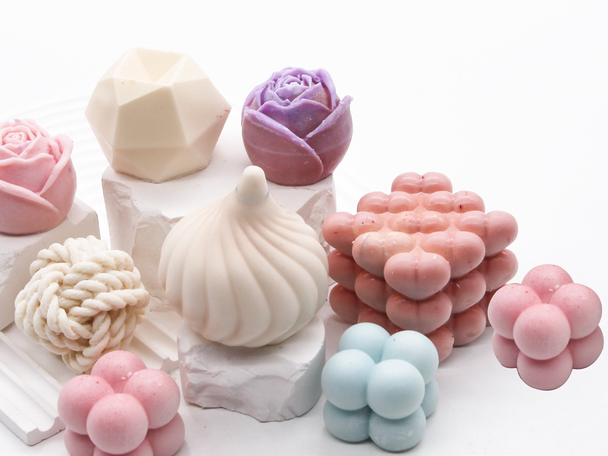 Assortment of decorative silicone molds in various shapes including roses, geometric, and bubble clusters, displayed on white blocks.