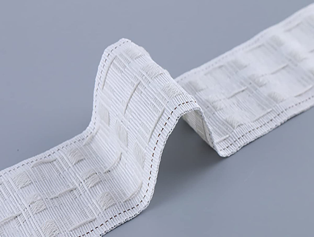 White curtain pleating tape with a textured grid pattern, shown on a gray surface.