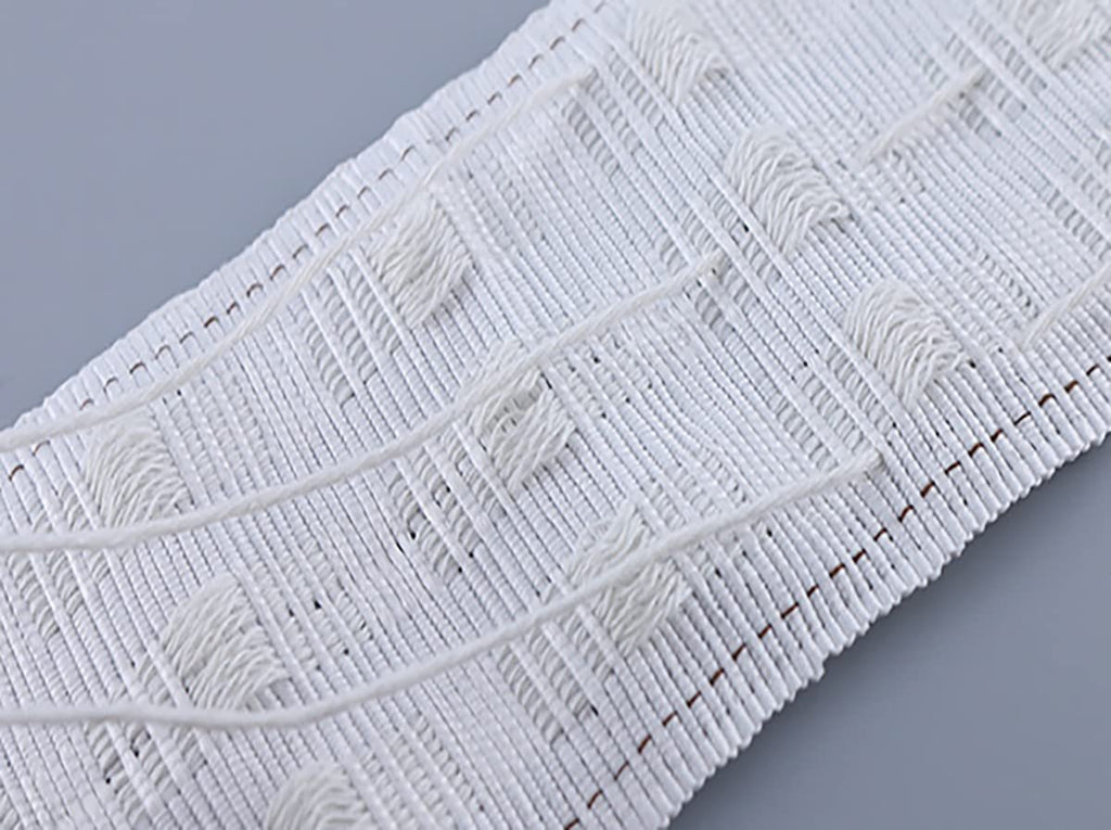 Close-up of white curtain pleating tape with woven texture and small loops for hanging hooks.
