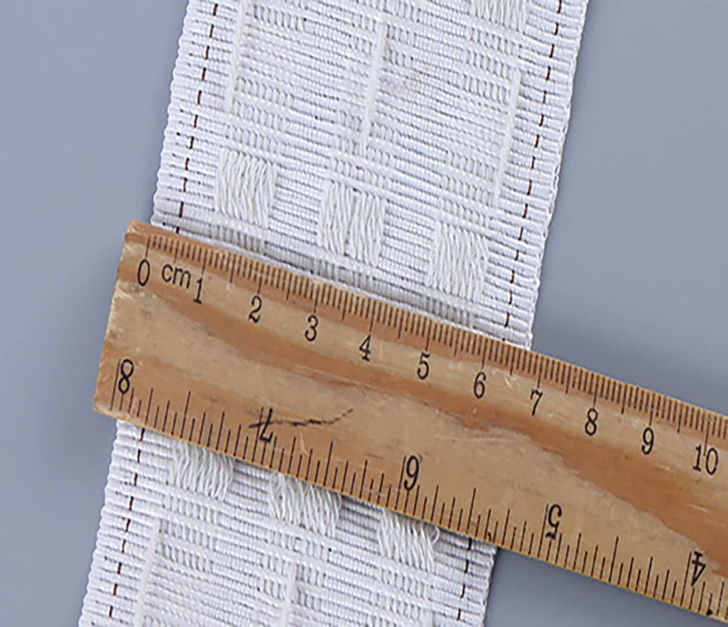 White curtain pleating tape with a wooden ruler measuring its width, showing 2.8 inches.