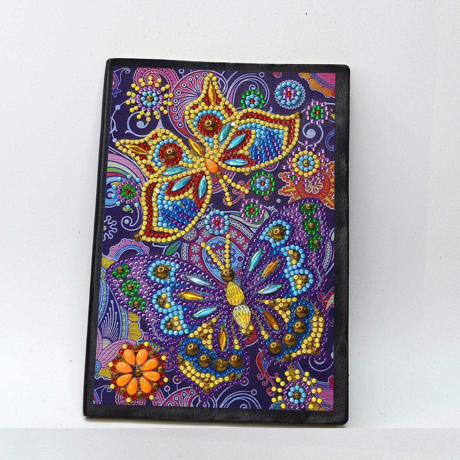 Diamond painting journal cover with two colorful butterflies and floral patterns, front view.