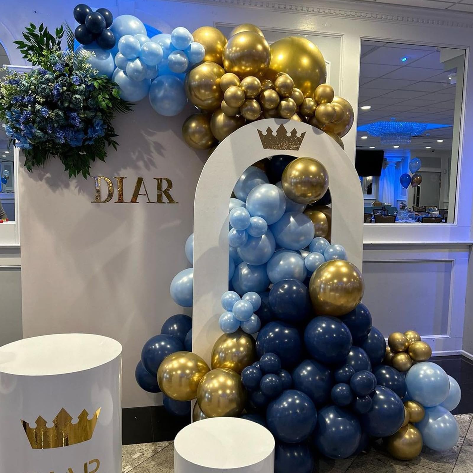 Balloon arch with navy blue, light blue, and gold balloons, featuring a decorative archway with a crown and the name DIAR.