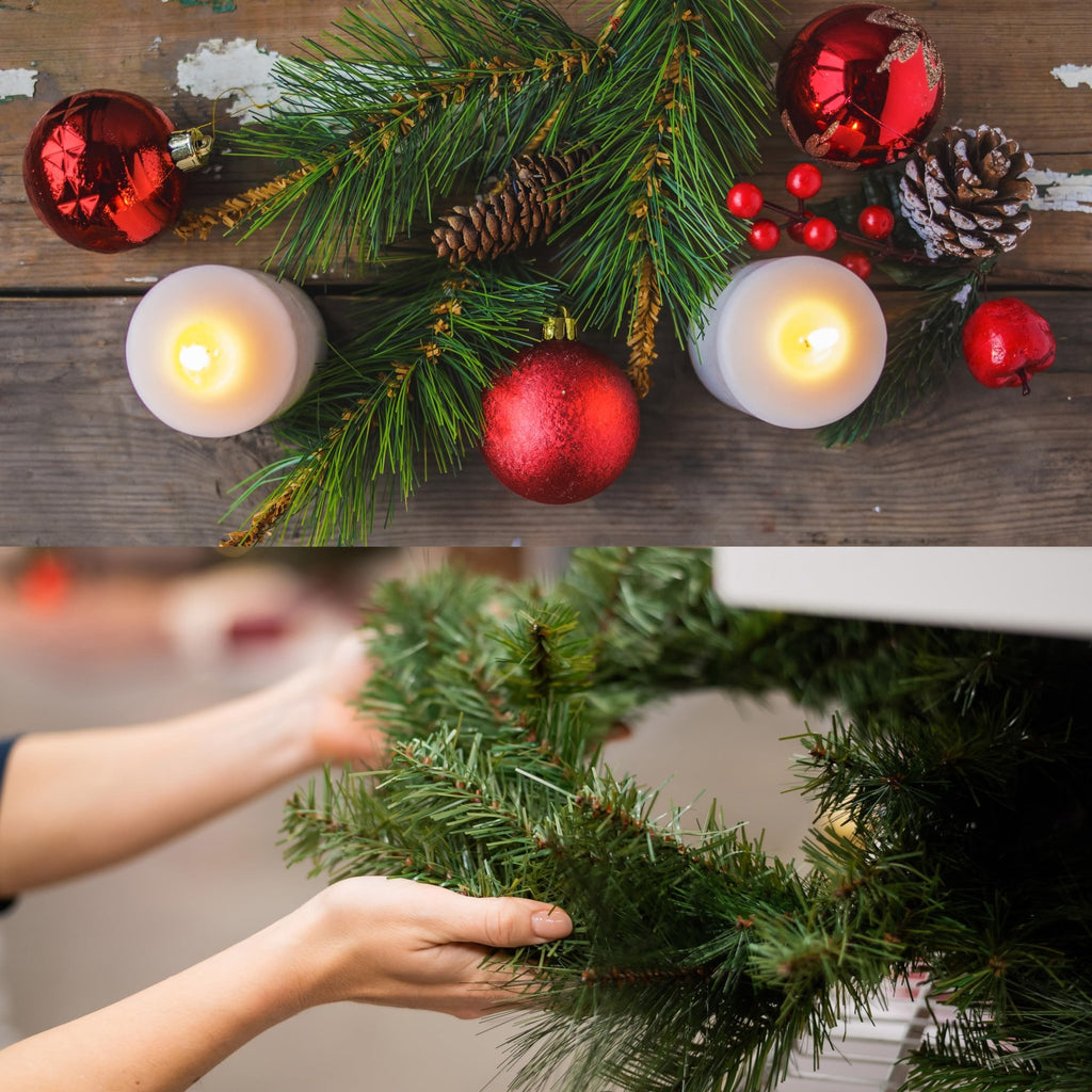 Christmas pine garland with red ornaments, pinecones, berries, and lit candles on a wooden surface, and hands arranging garland.