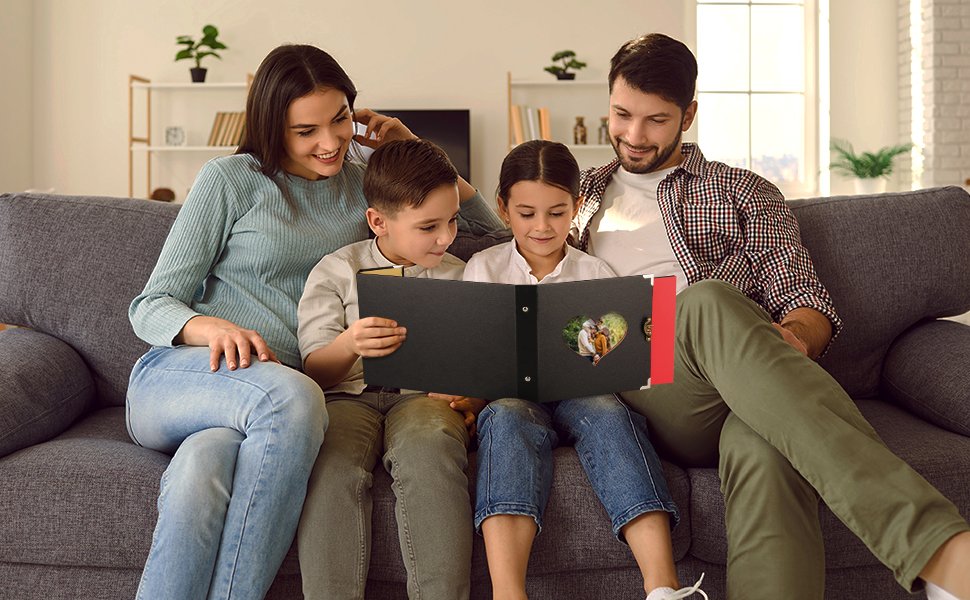 Family looking at a black scrapbook photo album with a heart-shaped cutout showing a photo of two elderly people.