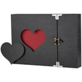 Black scrapbook album with a cutout heart revealing a red interior, featuring a decorative heart embellishment and a clasp closure.