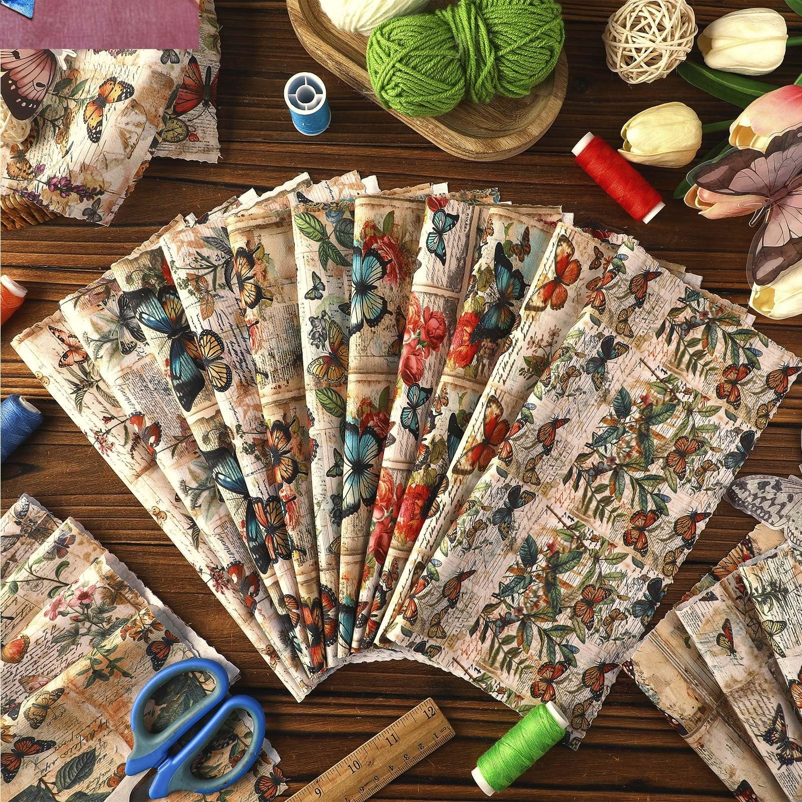 Fan of vintage butterfly fabric squares with sewing notions including scissors, thread, and a ruler on a wooden table.