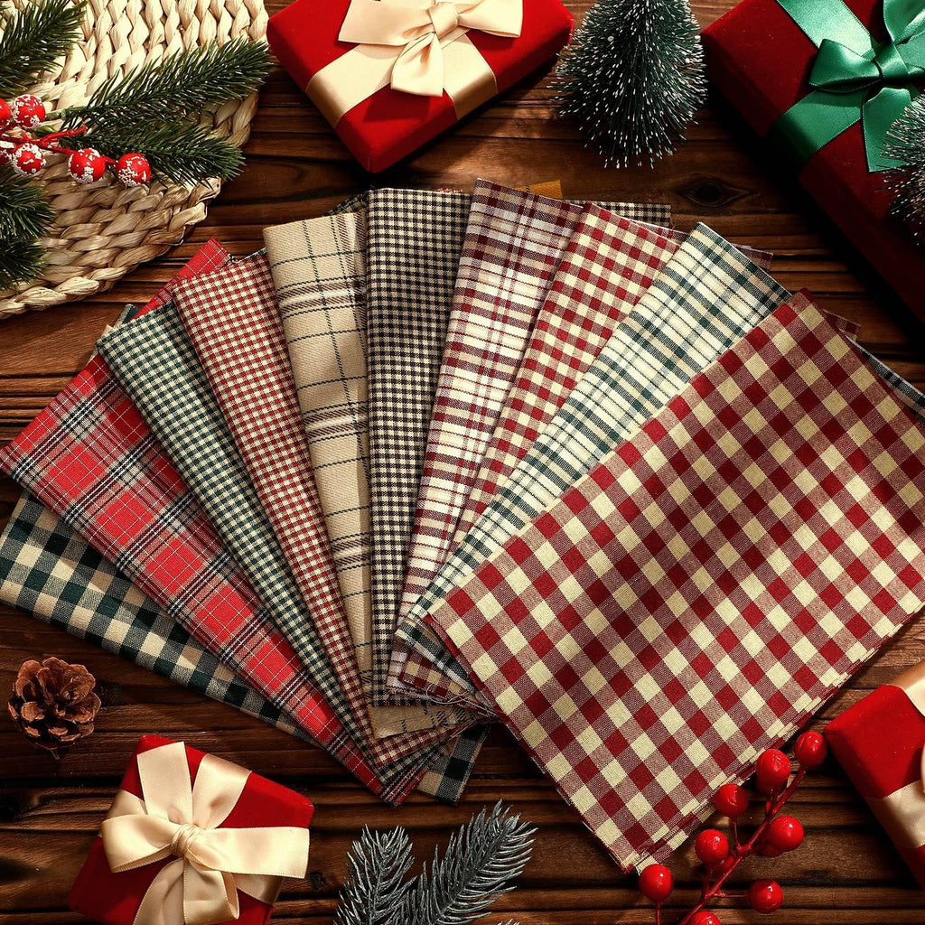 Fan of plaid fabric squares in red, green, and beige, arranged on a wooden surface with Christmas decorations.