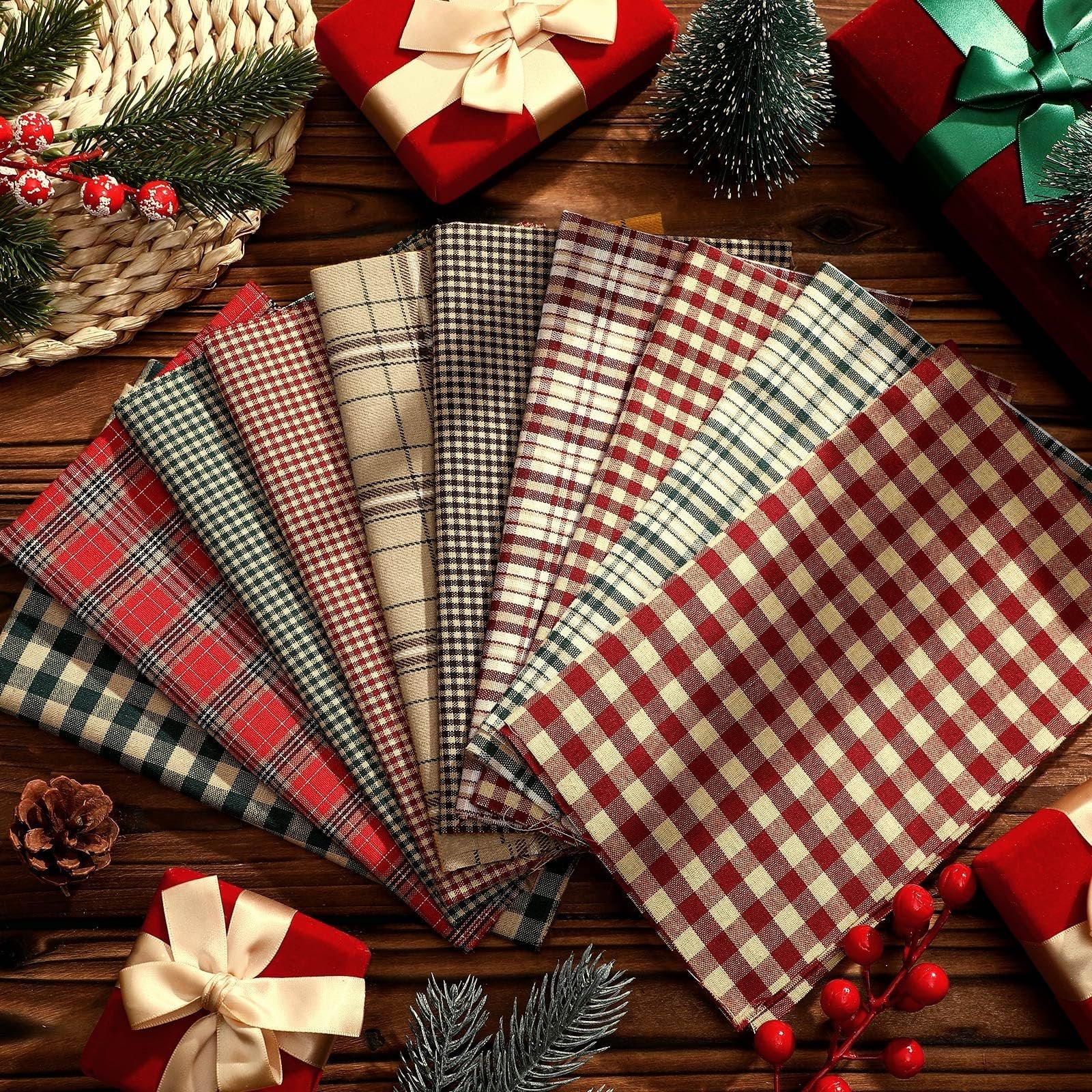 Fan of plaid fabric squares in red, green, and beige, arranged on a wooden surface with Christmas decorations.