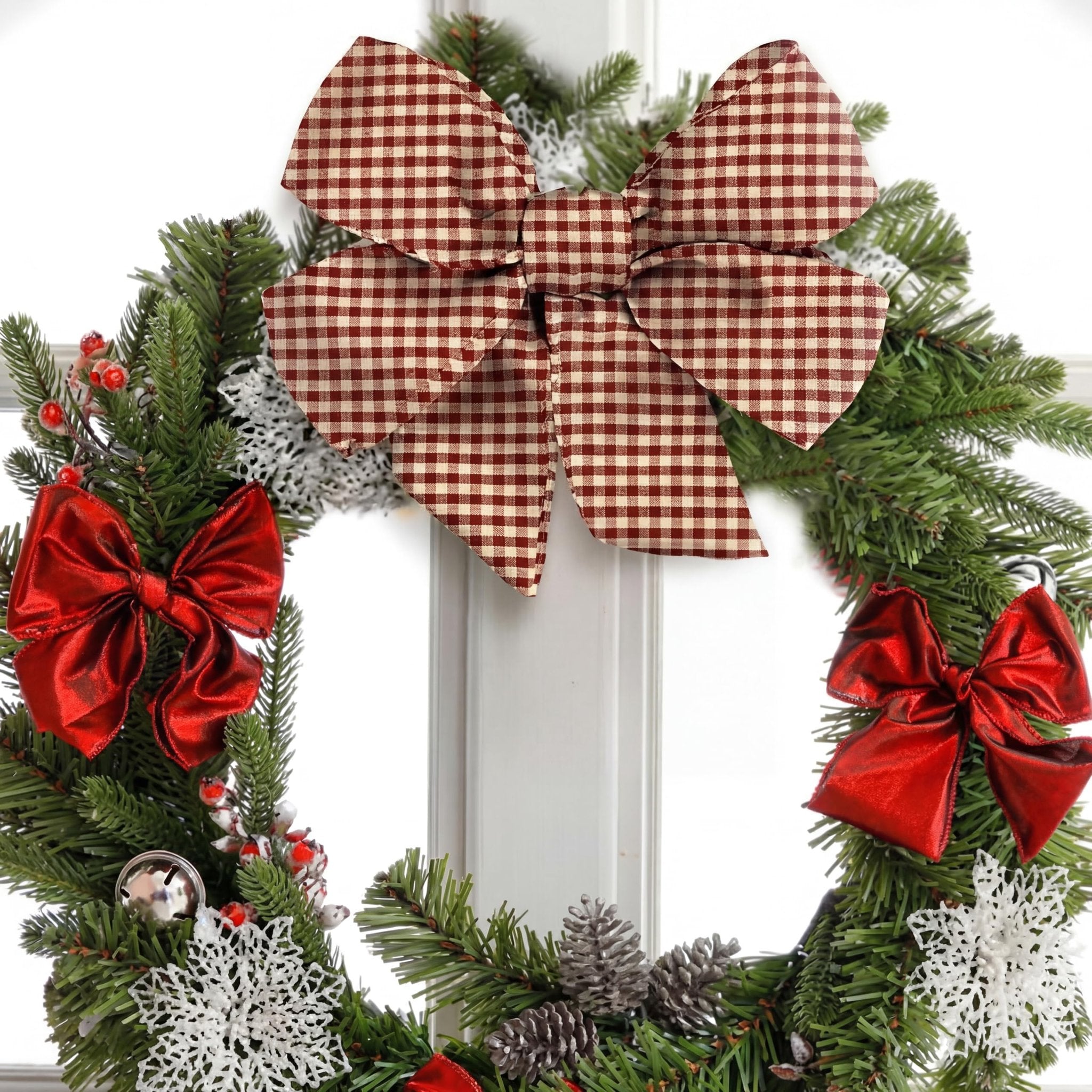 Christmas wreath with plaid bow, red bows, pinecones, and snowflakes on a white background