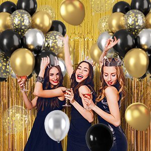 Three women celebrating with black, gold, and silver balloons, some with confetti, against a gold fringe backdrop.