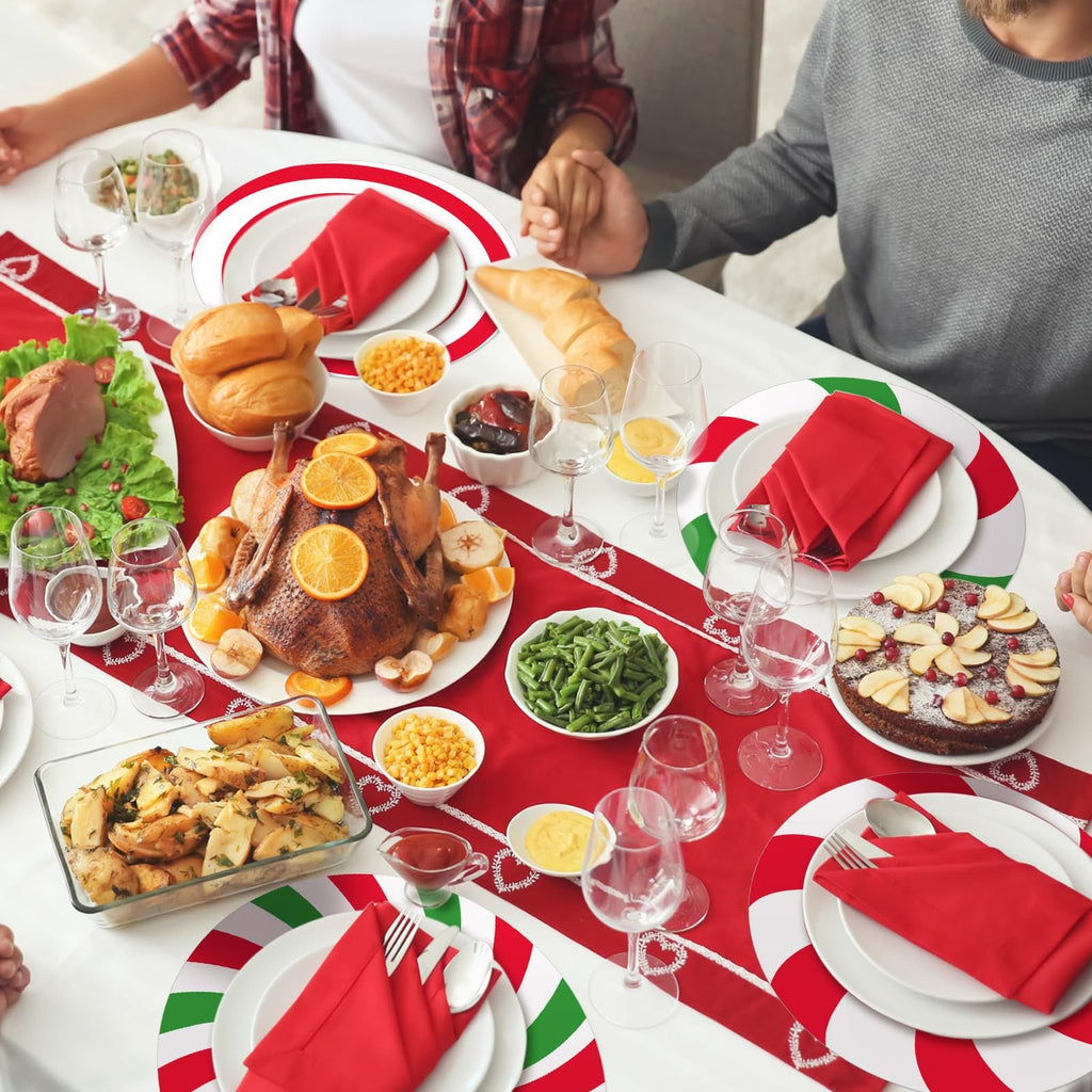 Christmas dinner table setting with roasted duck, side dishes, and festive placemats. A family holds hands in prayer.