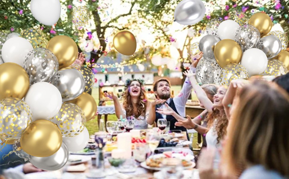 Metallic gold, silver, and white confetti balloons floating above a celebratory outdoor party with people laughing and throwing confetti.