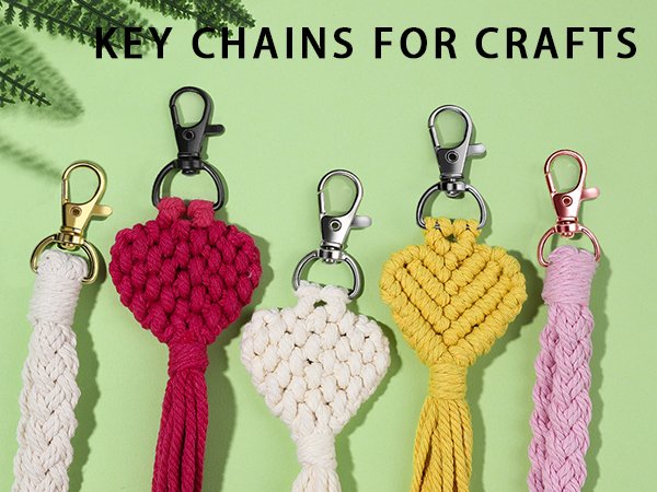 Five macrame keychains with heart designs and braided tassels in various colors and clasp finishes.