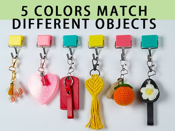 Assortment of colorful keychains hanging from hooks, including a heart, a macrame design, and a crocheted orange.