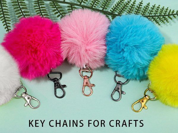 Fluffy pom pom keychains in white, pink, blue, and yellow with assorted metal clasps.