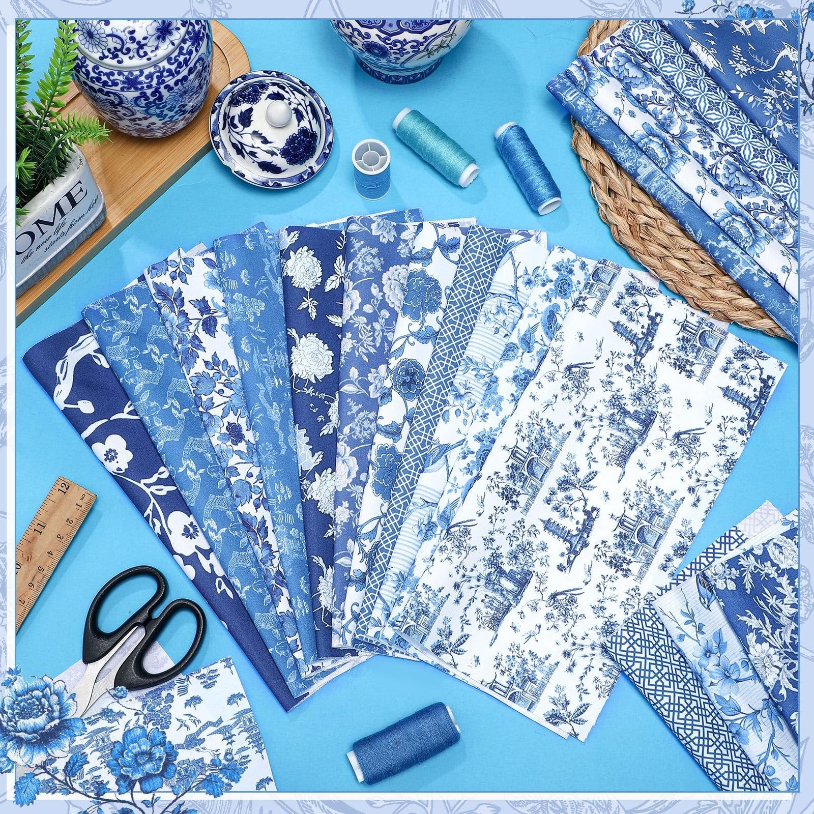 Collection of blue and white chinoiserie fabric squares fanned out with scissors and a ruler, plus spools of thread.
