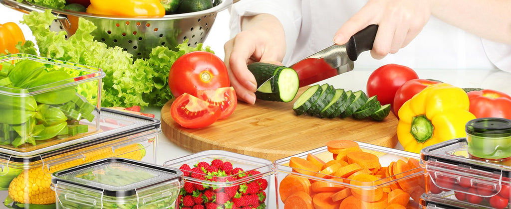 Food storage containers filled with fresh produce, a person slicing cucumber on a cutting board.