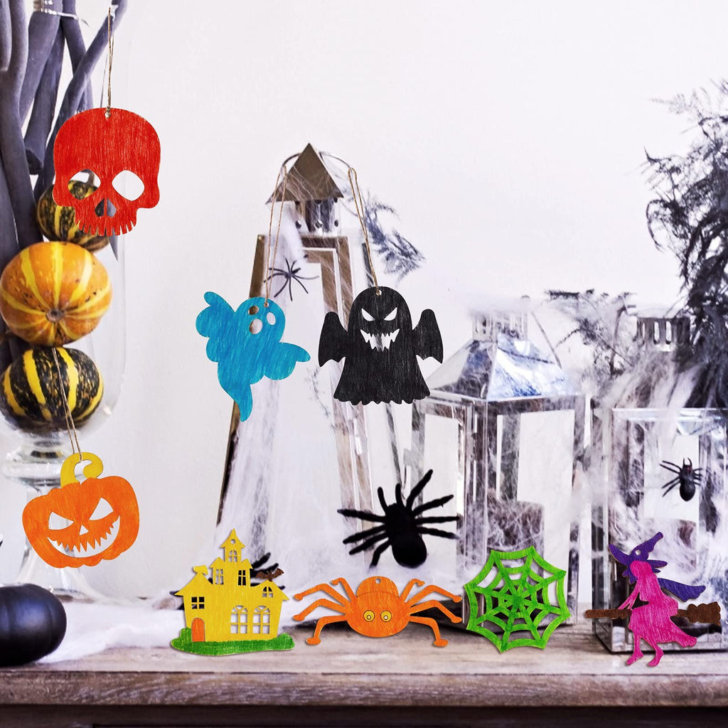 Halloween wooden craft ornaments including a skull, ghost, pumpkin, haunted house, spider, spiderweb, and witch, displayed with pumpkins and lanterns.