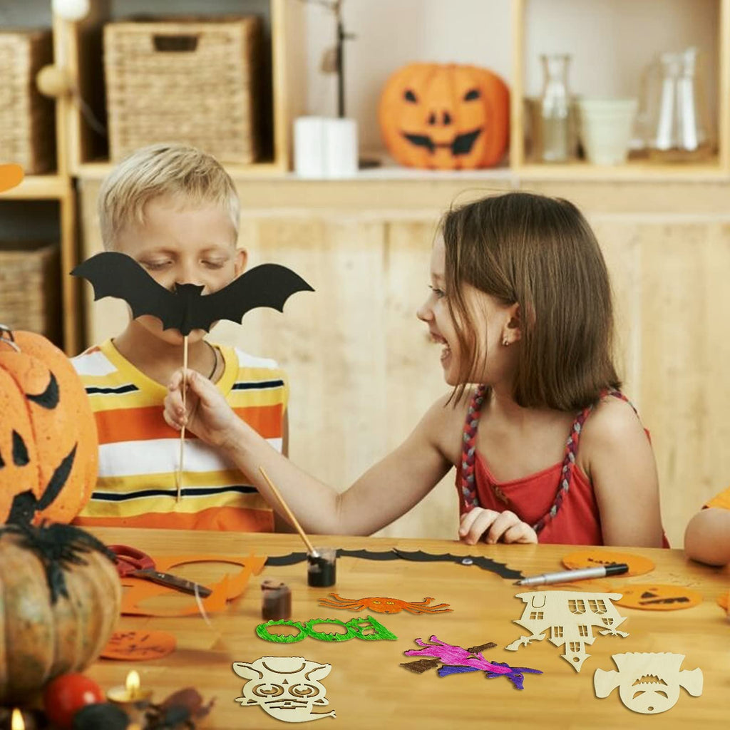 Children crafting Halloween wooden ornaments, one holding a bat cutout, others painting on a table with pumpkins and craft supplies.