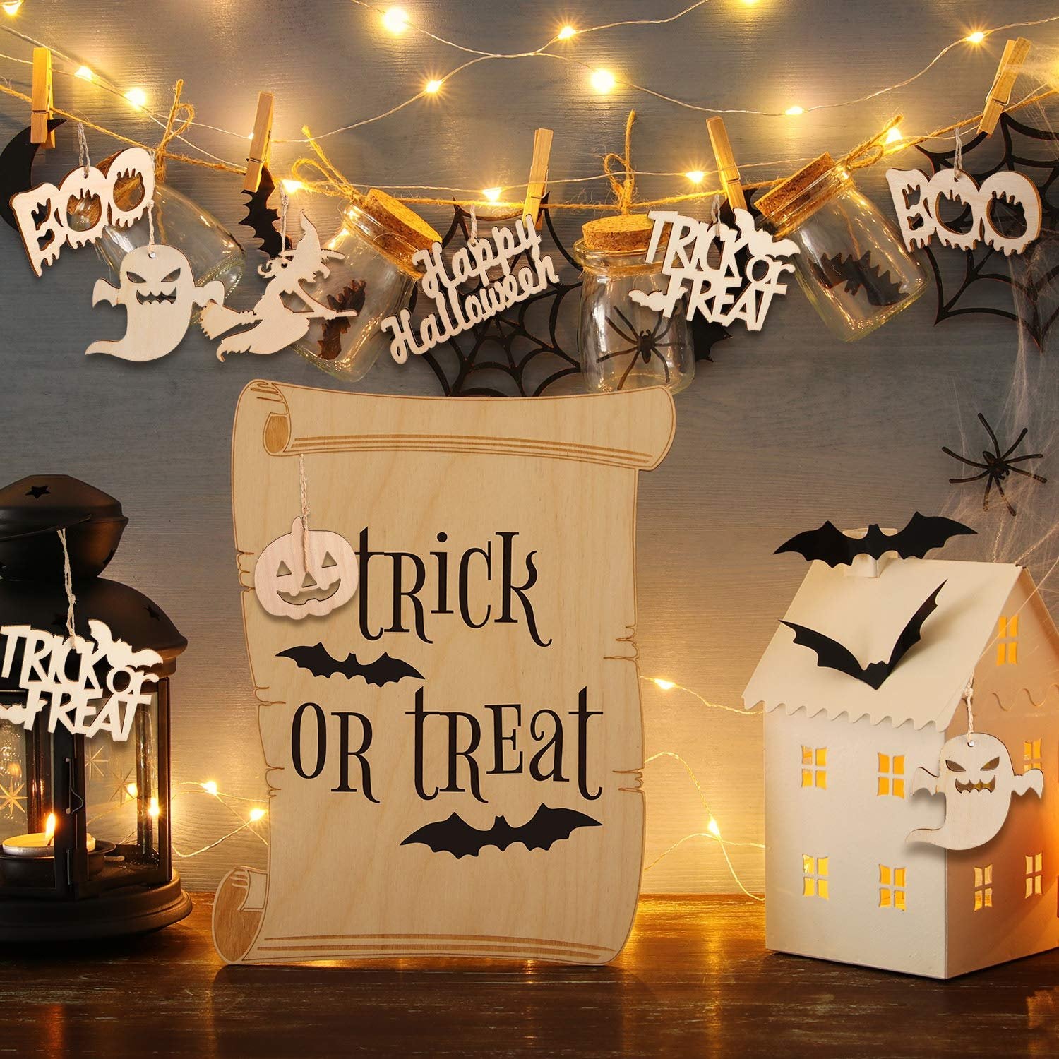 Halloween decorations including wooden ornaments with 'Trick or Treat' and 'Happy Halloween' text, hanging on string lights.