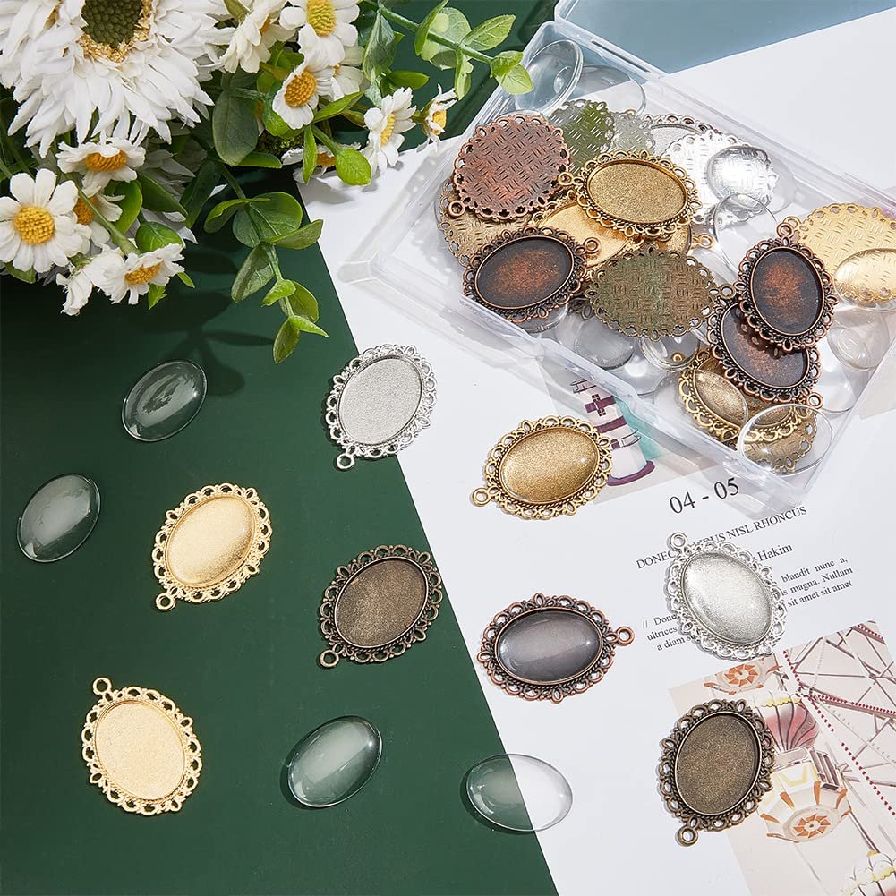 Oval pendant trays and glass cabochons scattered on a green and white surface with floral accents.