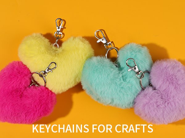 Fluffy heart-shaped keychains in pink, yellow, mint green, and purple with silver clasps on an orange background.