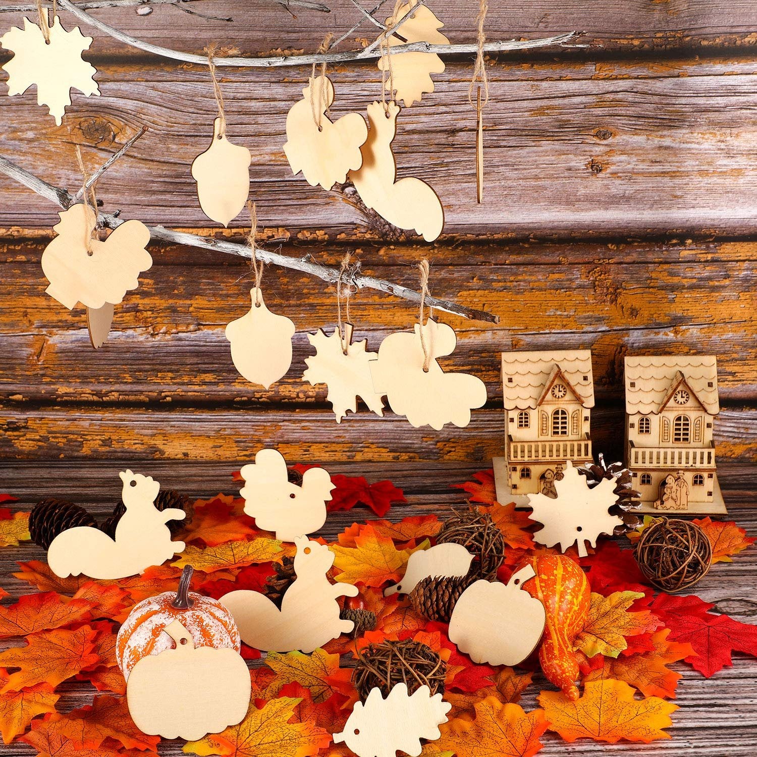 Unfinished wood Thanksgiving ornaments in various fall shapes like pumpkins, turkeys, squirrels, and leaves, displayed on branches and autumn leaves.
