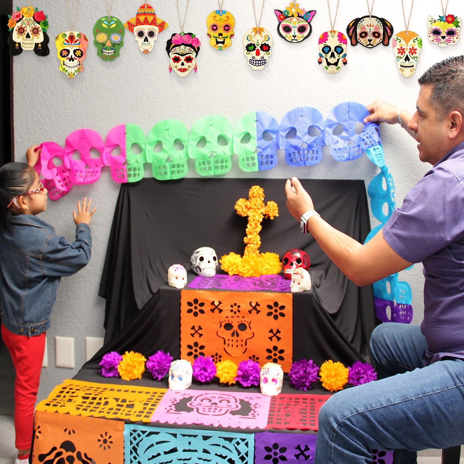 Father and daughter decorating for Dia de Muertos with skull ornaments and papel picado banners