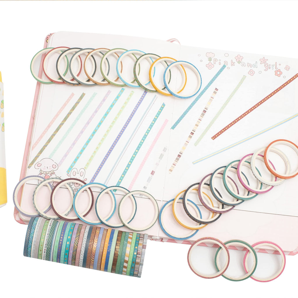 Assortment of skinny gold foil washi tapes arranged on an open journal with decorative lines and cartoon animals.